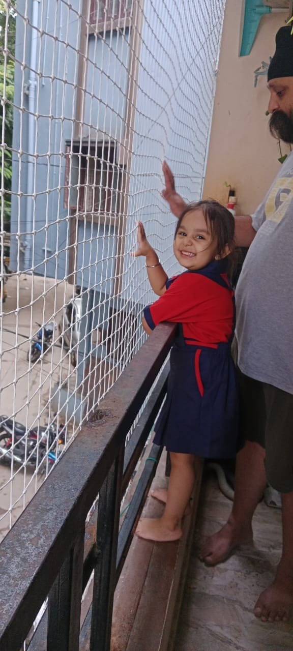 Child beside a white balcony safety net
