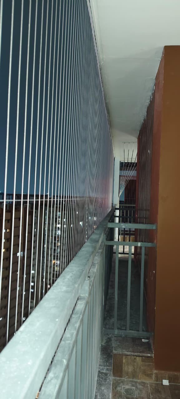 Invisible grills fitted along a high-rise apartment corridor