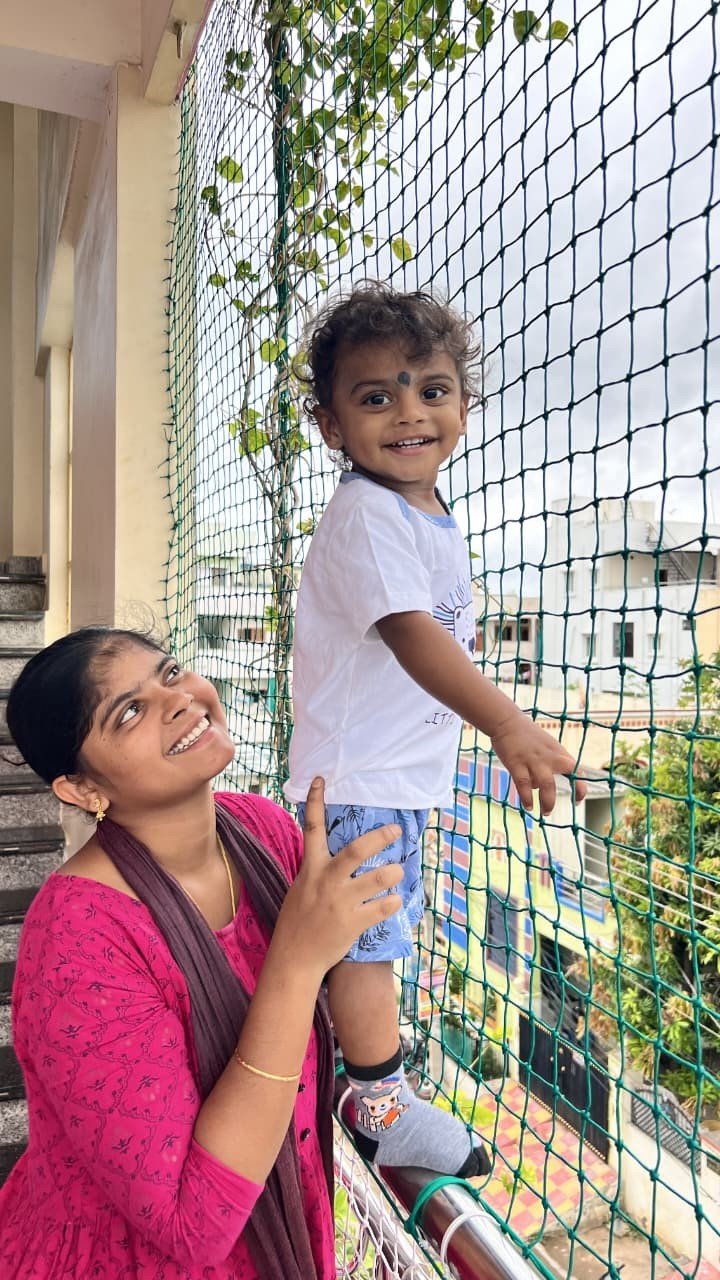 Mother and child protected by a safety net on their balcony