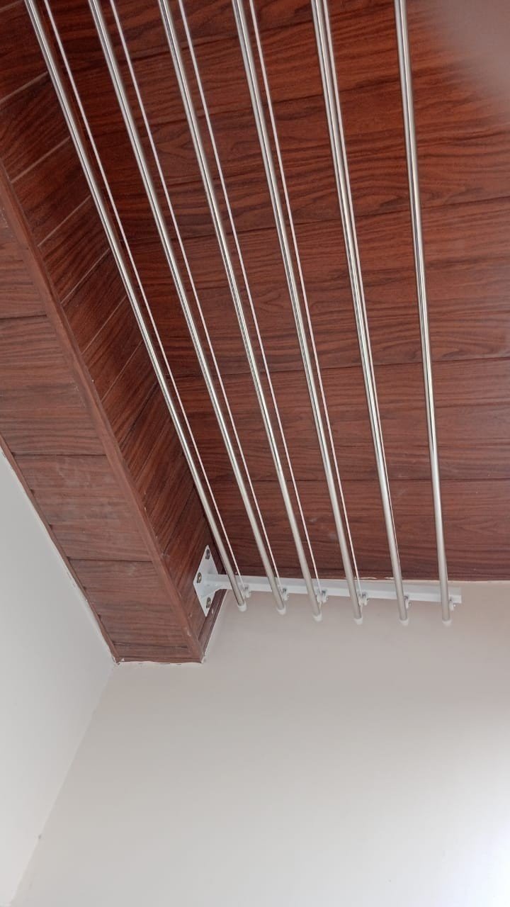 Finished stainless-steel cloth hanger under a wood-panel ceiling