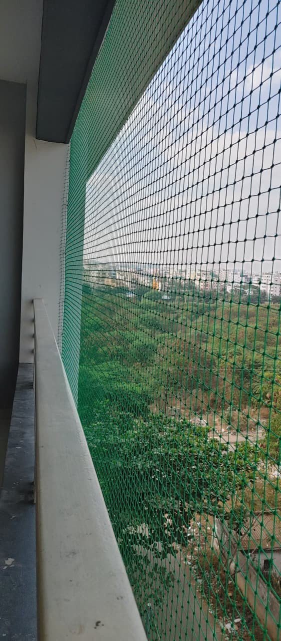 Green bird net protecting a large apartment balcony
