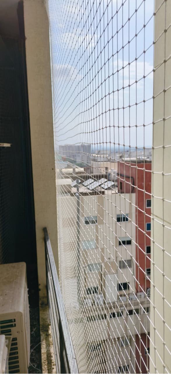 High-rise balcony protected by white pigeon netting