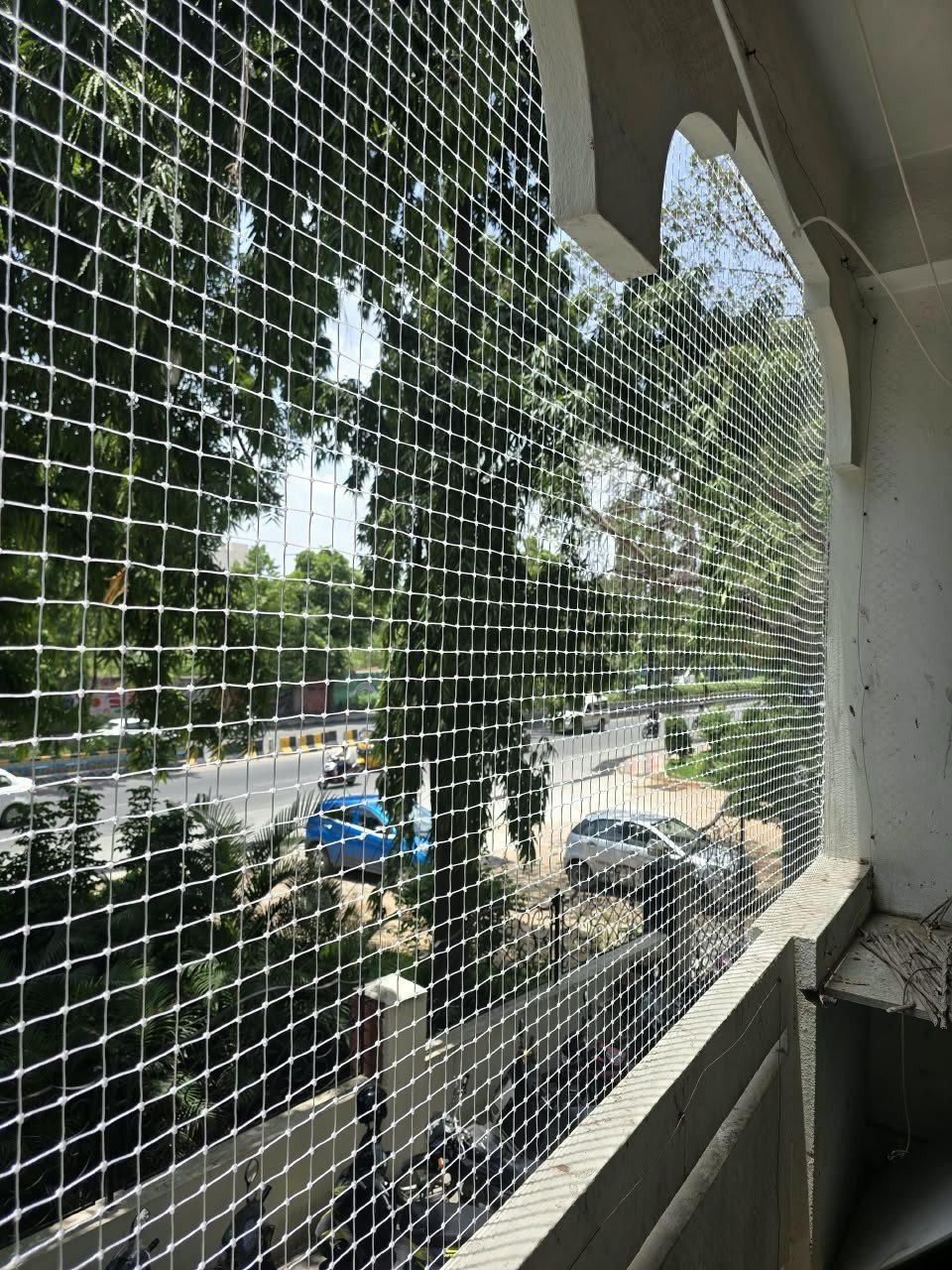 White bird protection net fitted across an open apartment balcony